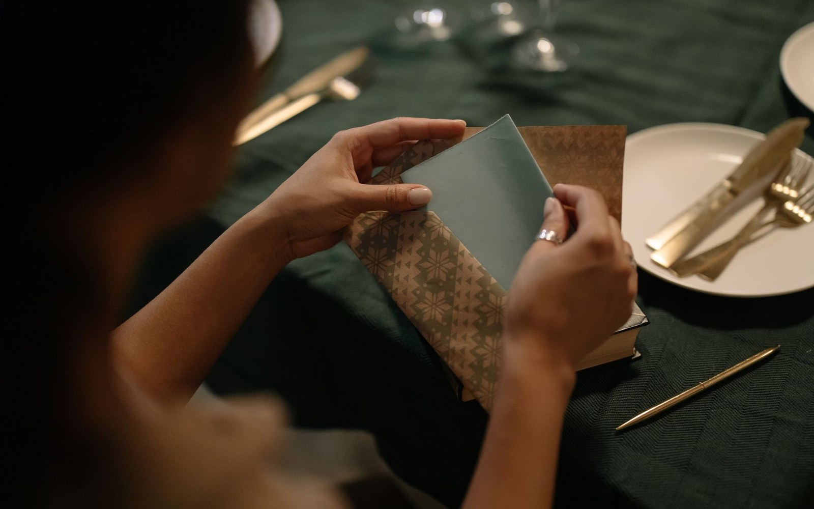 Saved Chimayó chile seed in a folded paper envelope, held open in adult hands